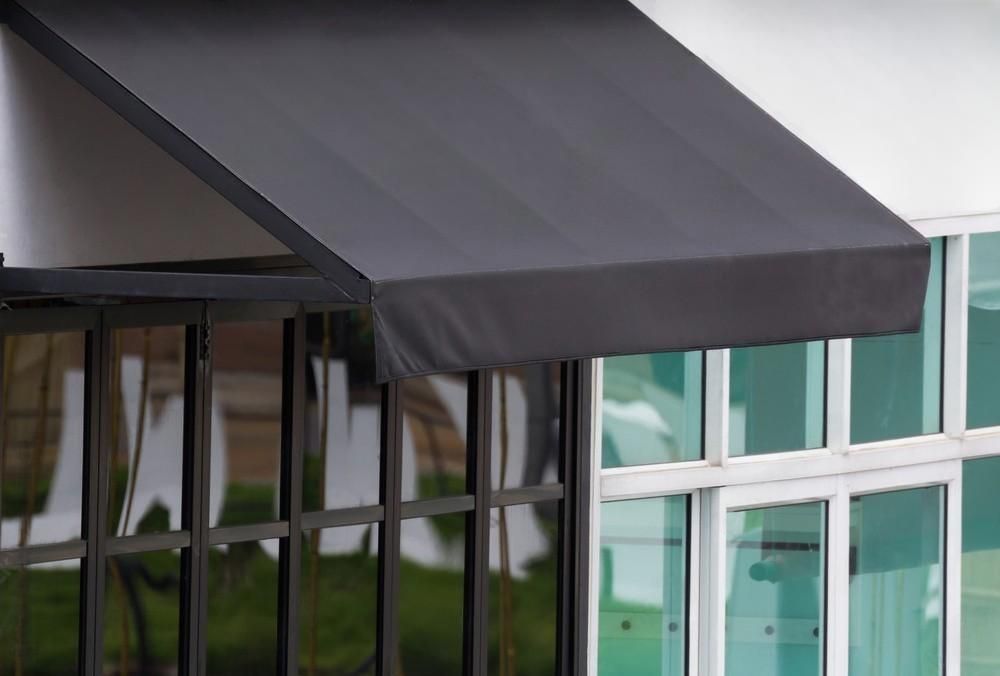 a black awning is on the side of a building .