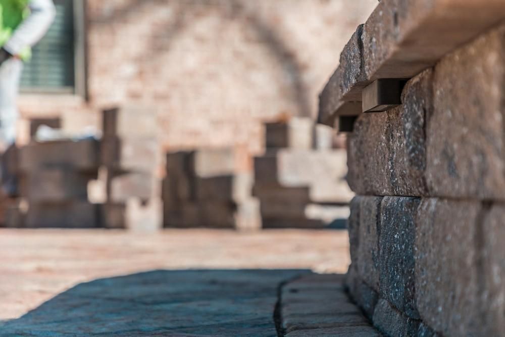 a close up of a stone wall being built on a sidewalk .