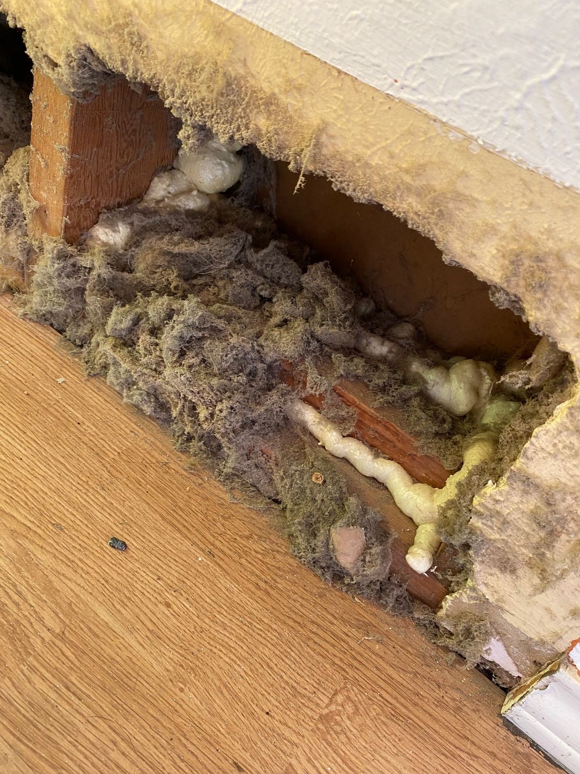 Hole in wall reveals insulation, brick, and foam. Hole in wall reveals insulation, brick, and foam.
