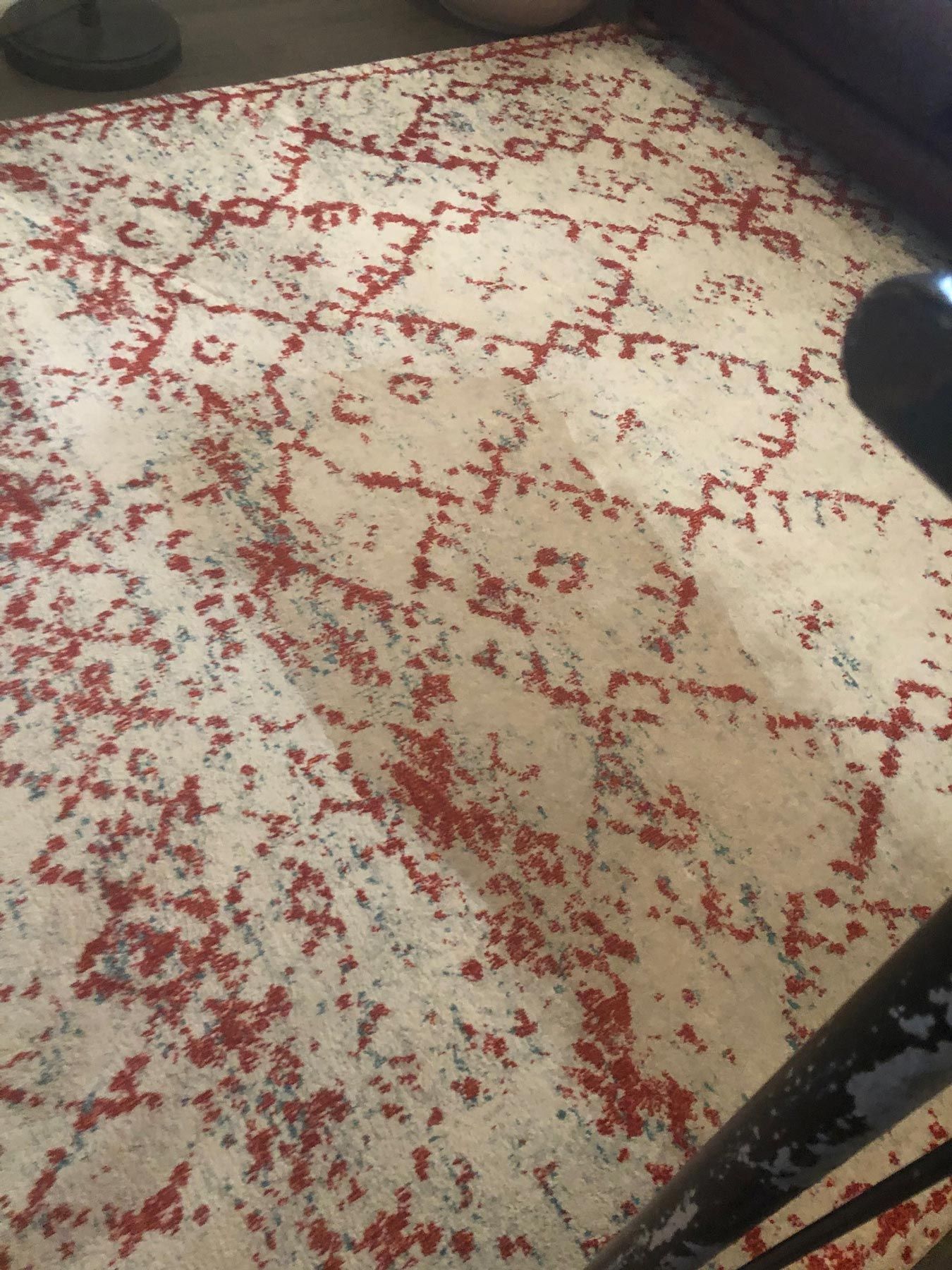 Beige rug with red geometric pattern on a wooden floor. Beige rug with red geometric pattern on a wooden floor.
