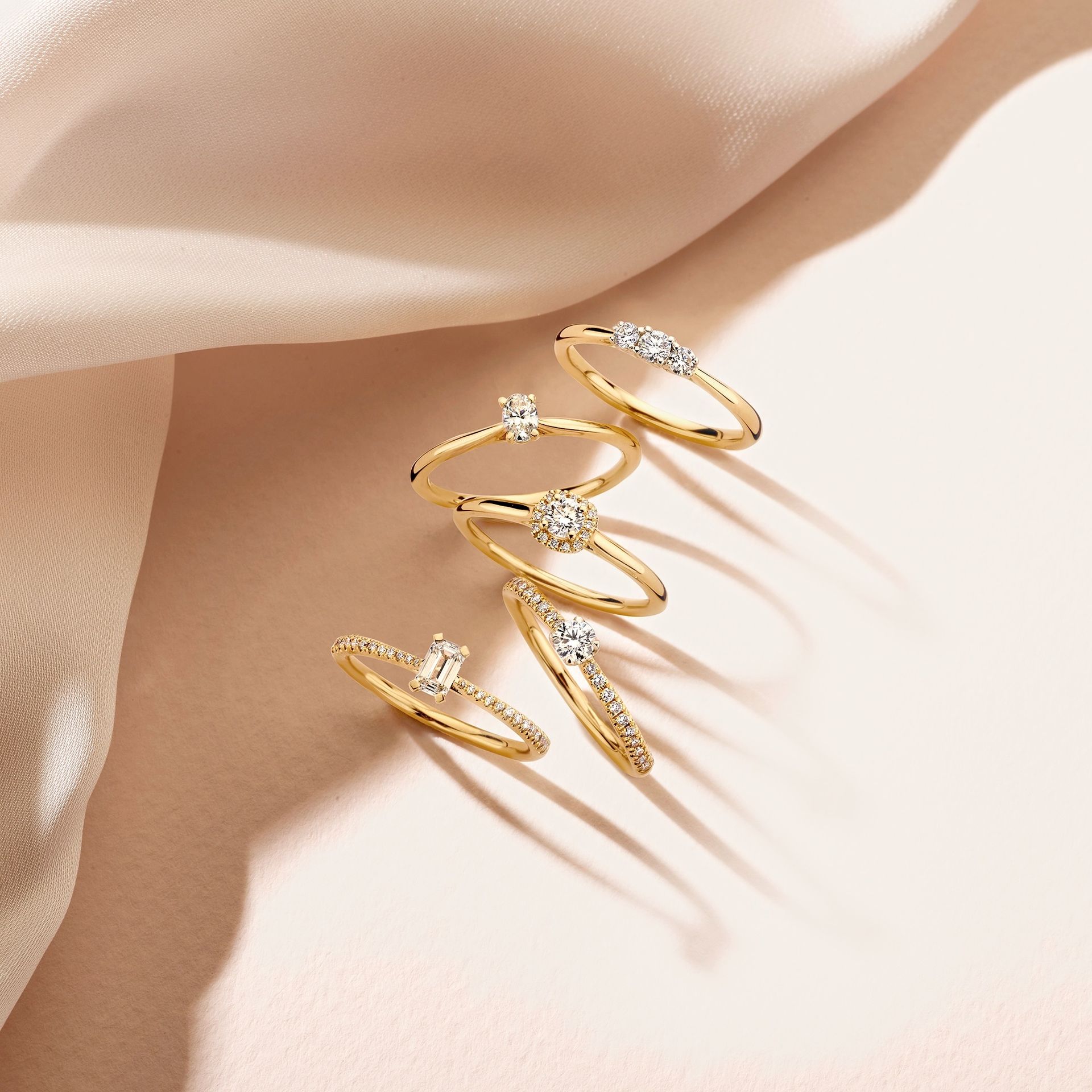 Gouden ringen met diamanten op zachtroze zijde
