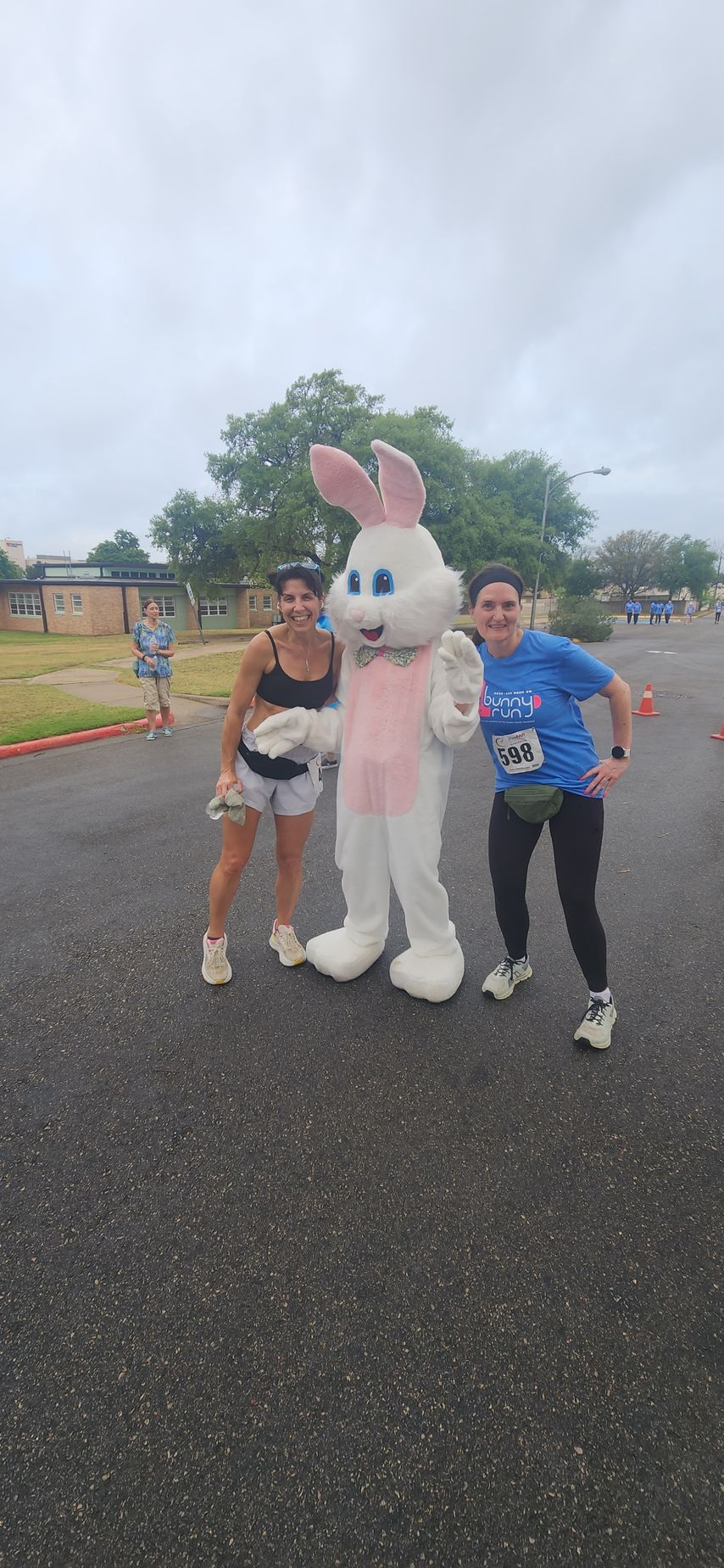 Two participants posing with the Easter Bunny at a Friends of ASH outdoor fundraising race event in Austin
