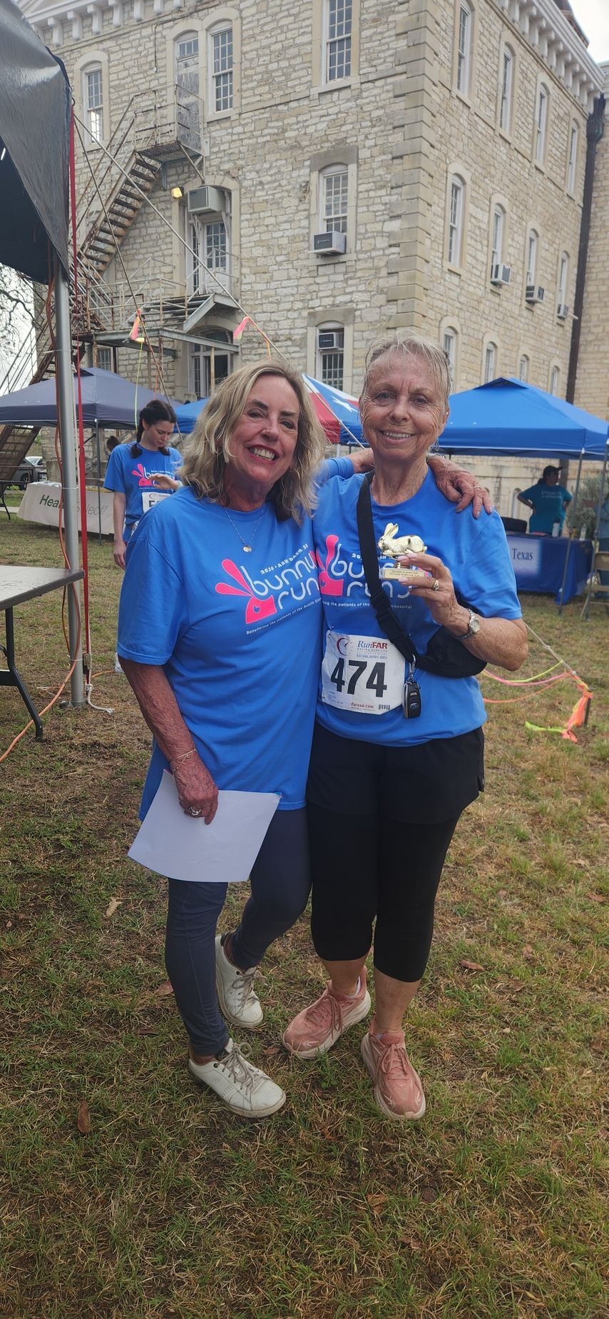 Two Friends of ASH Bunny Run volunteers smiling at an Austin community fundraising race event near Austin State Hospital
