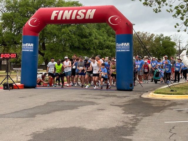 Friends of ASH Bunny Run participants and volunteers posing with a dog at an Austin community fundraising race event