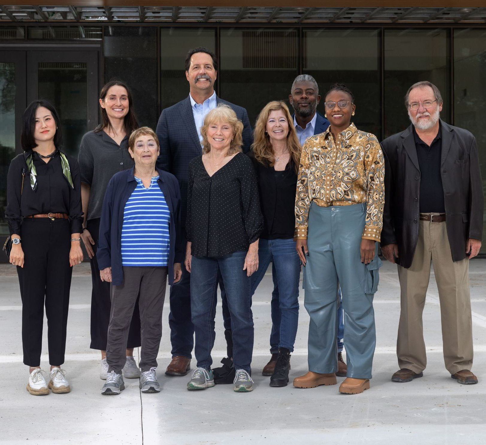 A group of people posing for a picture in front of a building