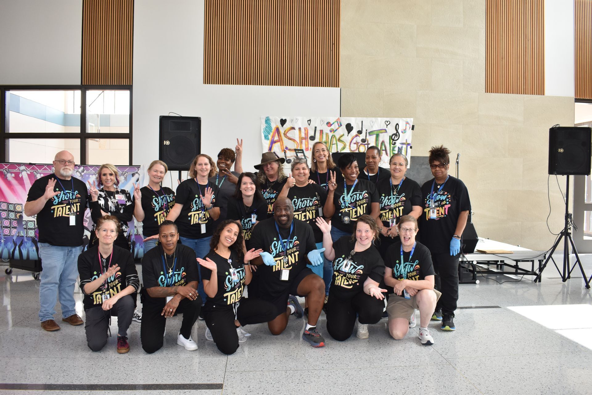 Volunteers  in matching black shirts posing outdoors at Austin State Hospital after talent show