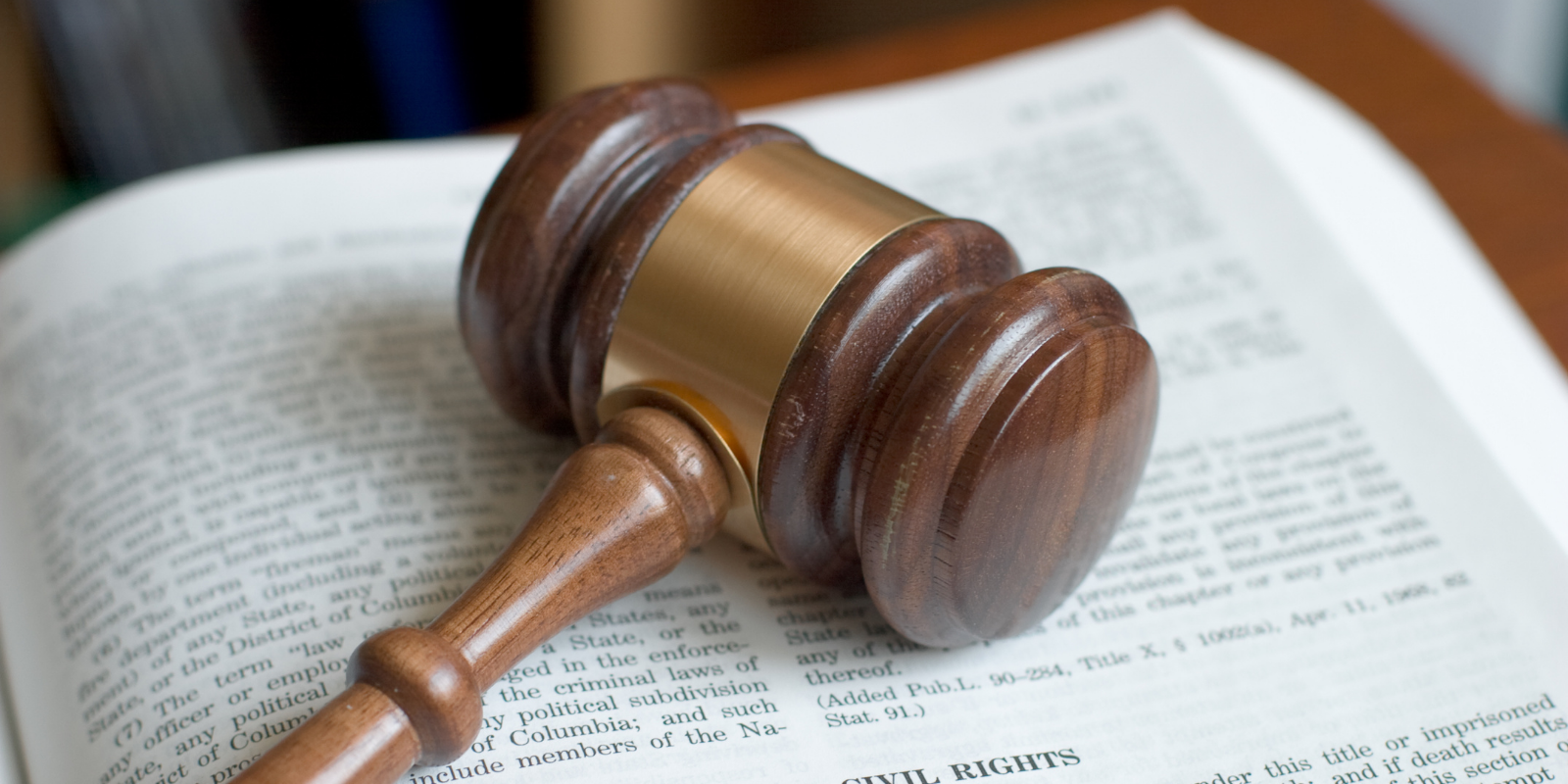 Wooden gavel resting on an open book, symbolizing law and justice