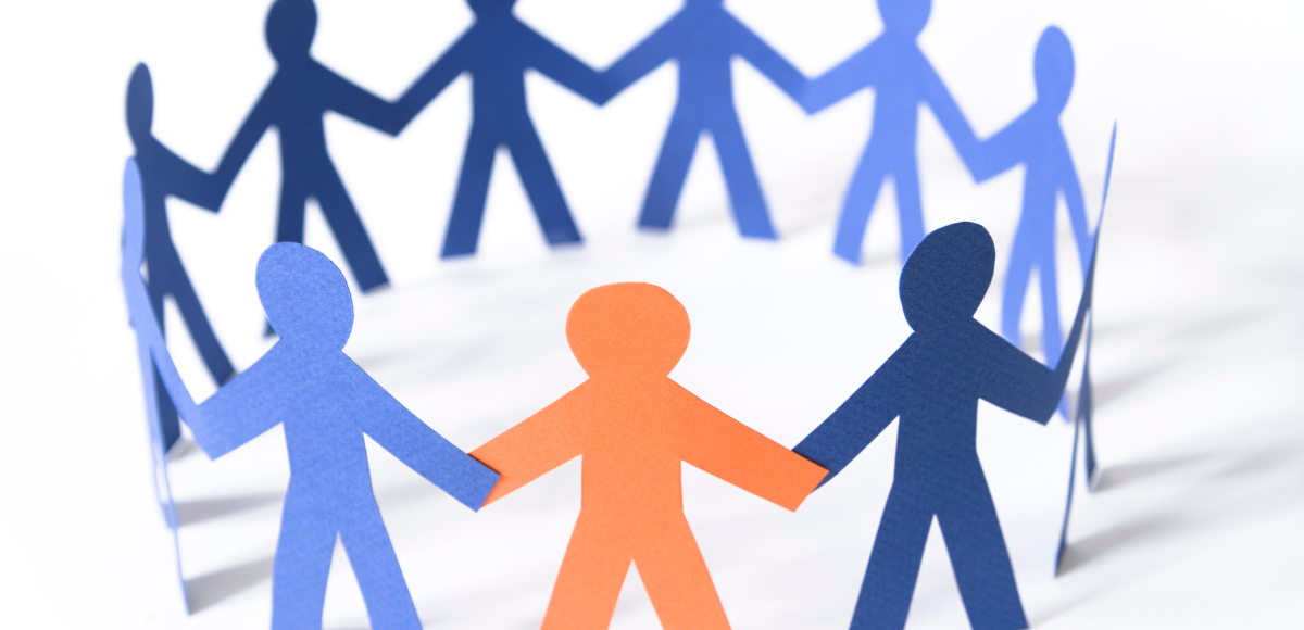 Paper chain of blue and orange human figures standing in a circle, linked hand to hand