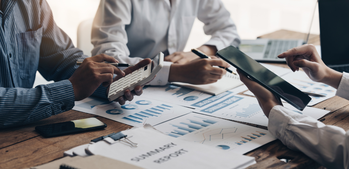 Colleagues reviewing charts and graphs on a table during a business meeting