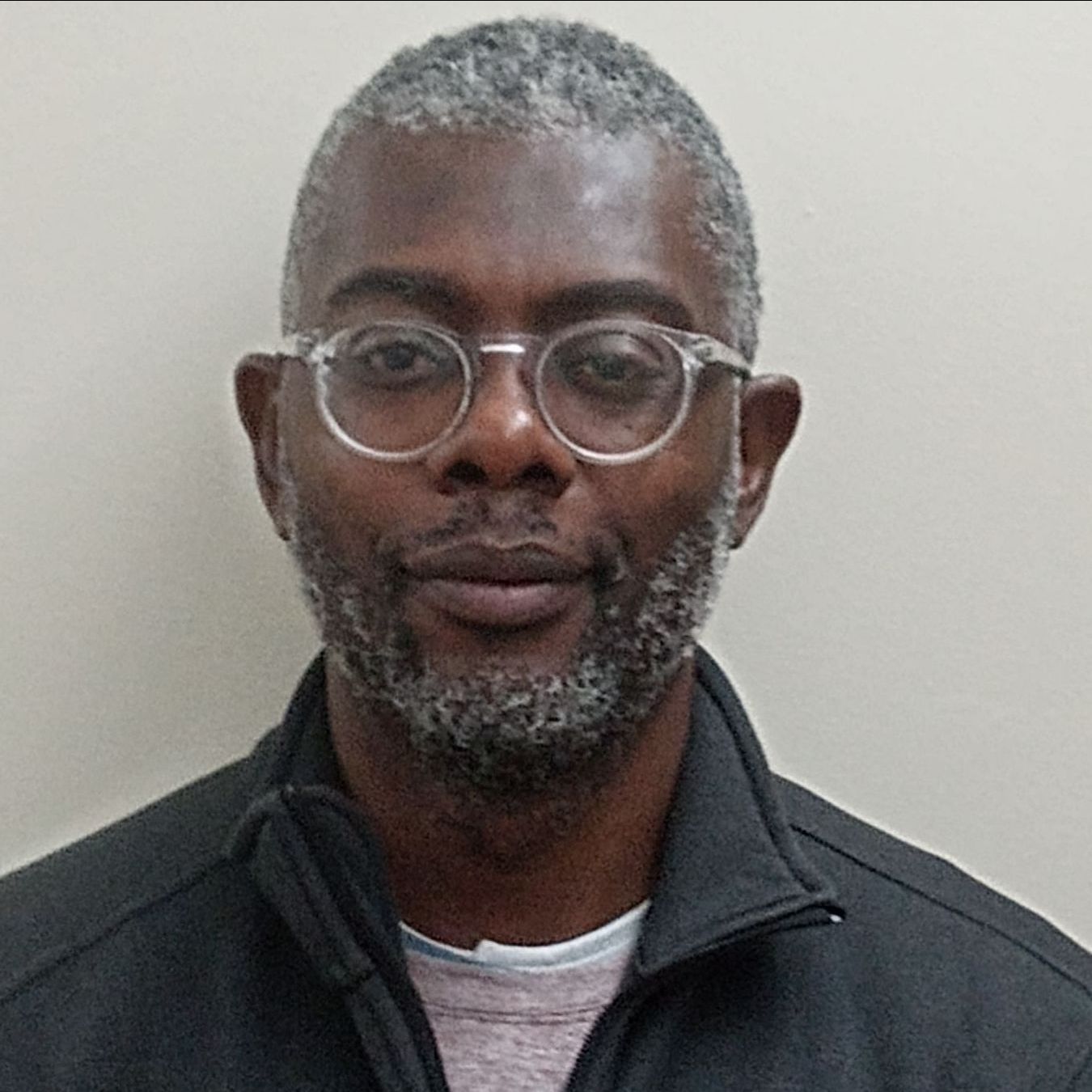 A man with glasses and a black jacket.