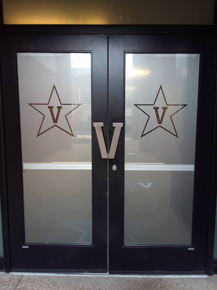 Black double doors with frosted glass, stars, and a large V logo at the center.