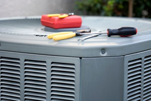 An HVAC unit, with repair tools on top, showcasing reliable AC Repair in Kalamazoo, MI.