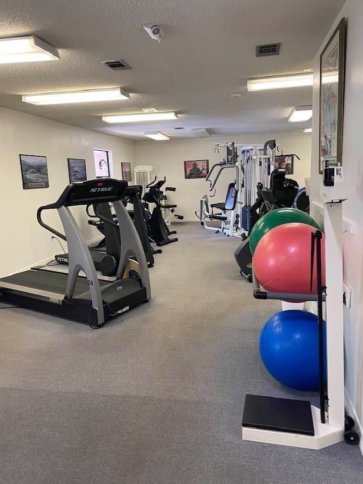 Gym room with treadmills, weight machines, and colorful exercise balls