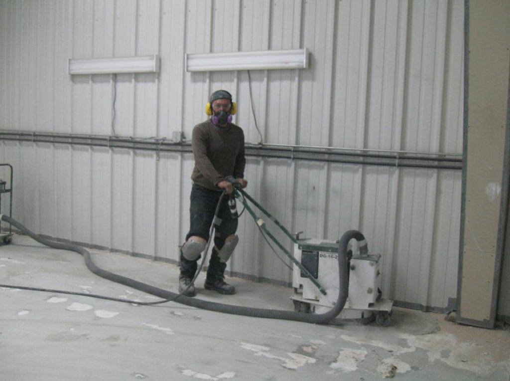 tech grinding the concrete floor