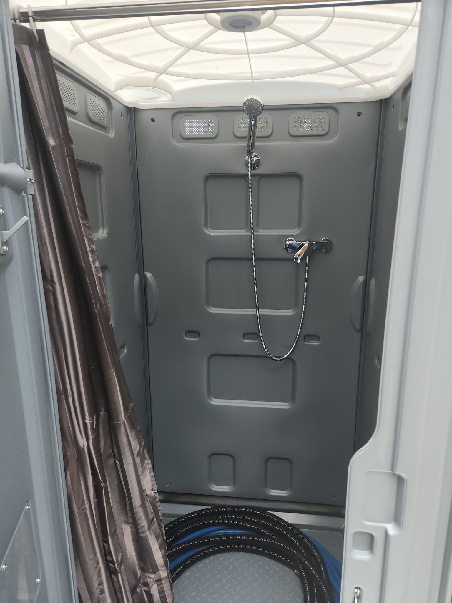 Interior of a Gray Portable Shower Unit With Showerhead — Royal Flush Luxury Toilet, Portaloo & Shower Hire in Gympie, QLD