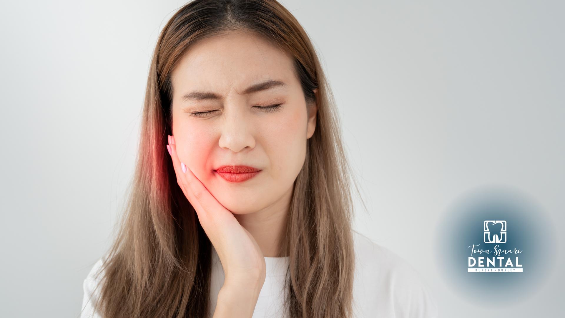 A woman is holding her face in pain because of a toothache.