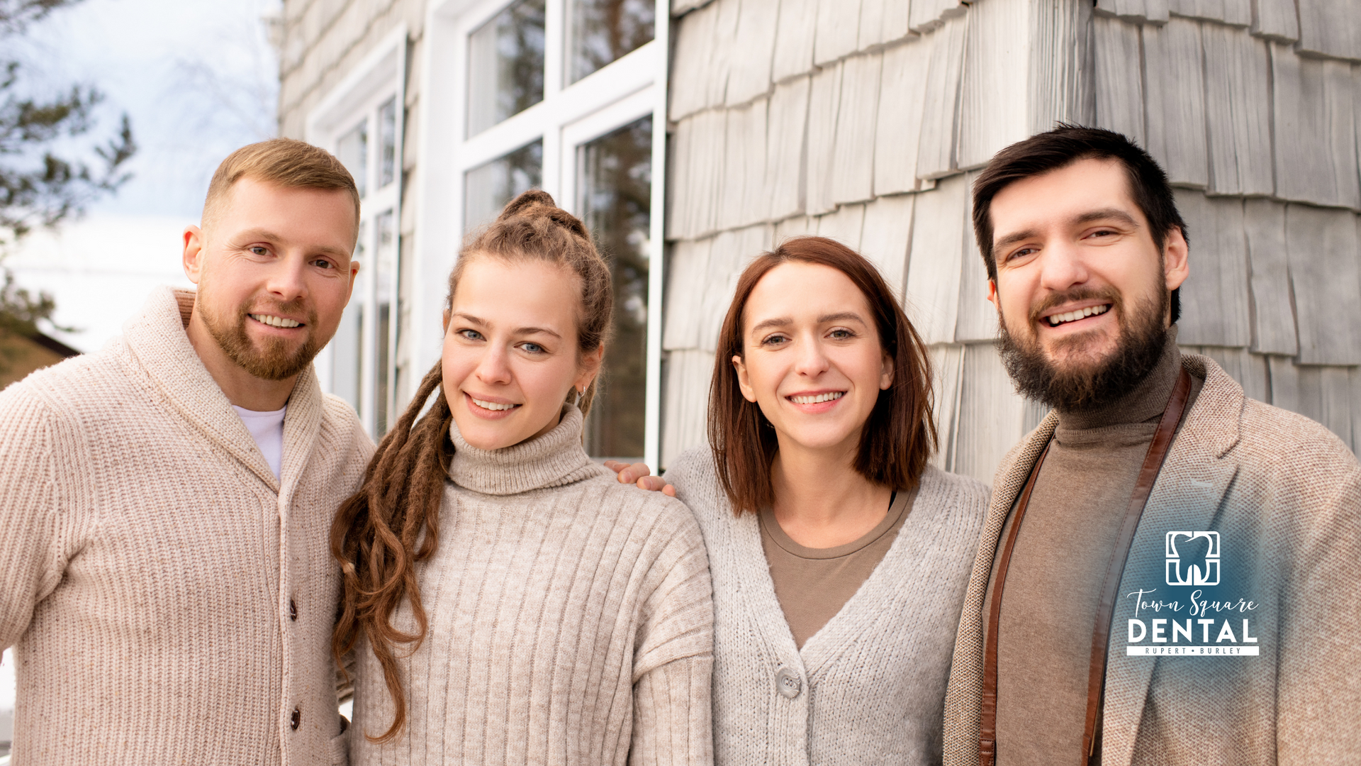 A group of people are posing for a picture in front of a house.