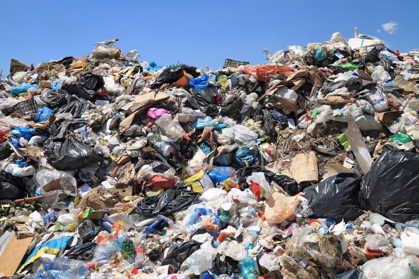 A large pile of garbage is sitting on top of a hill.