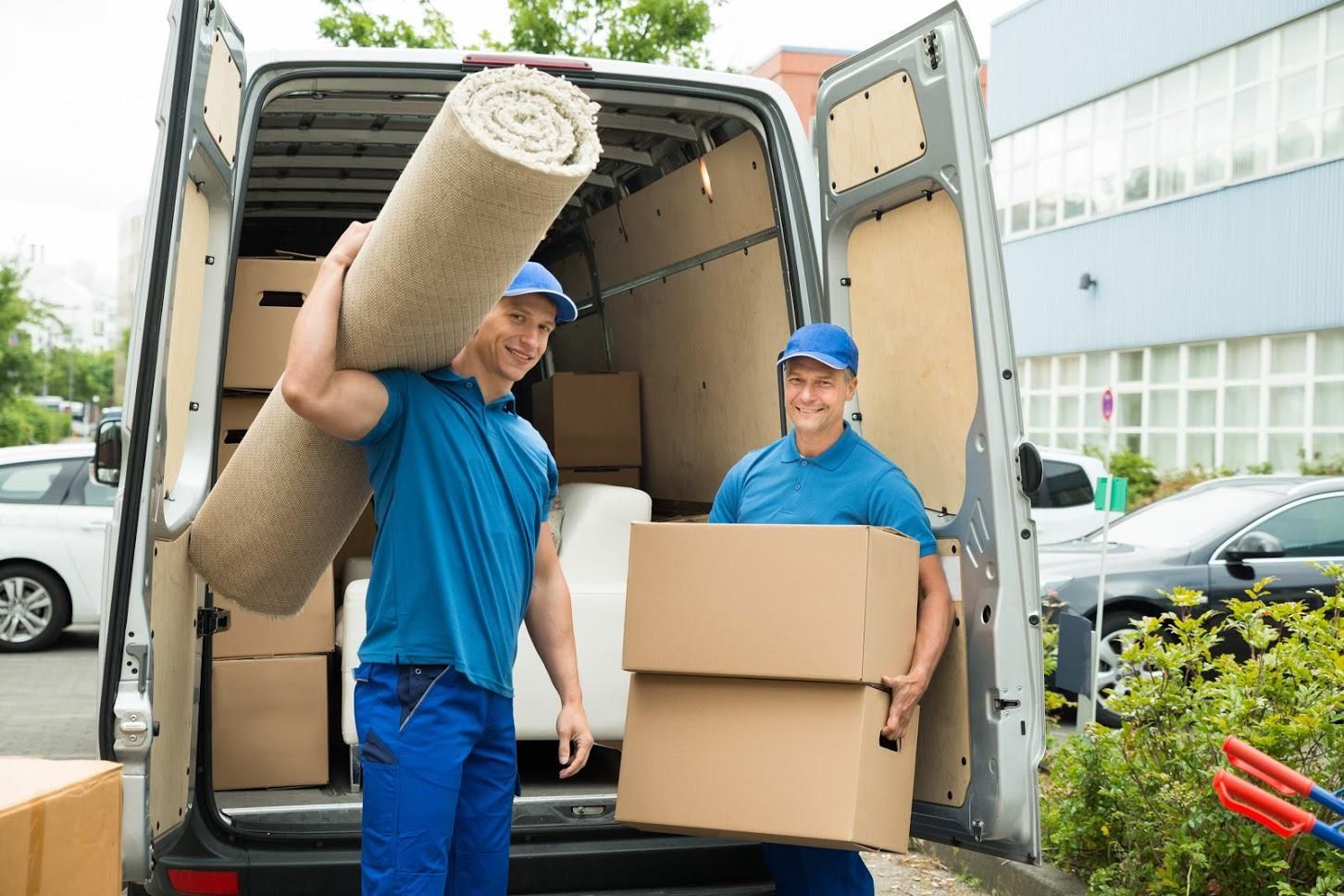 Two men are loading boxes into a moving van.