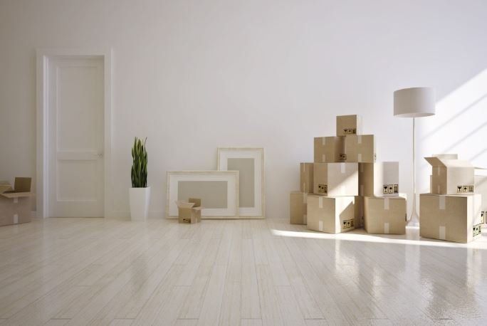 A room with a lot of cardboard boxes on the floor