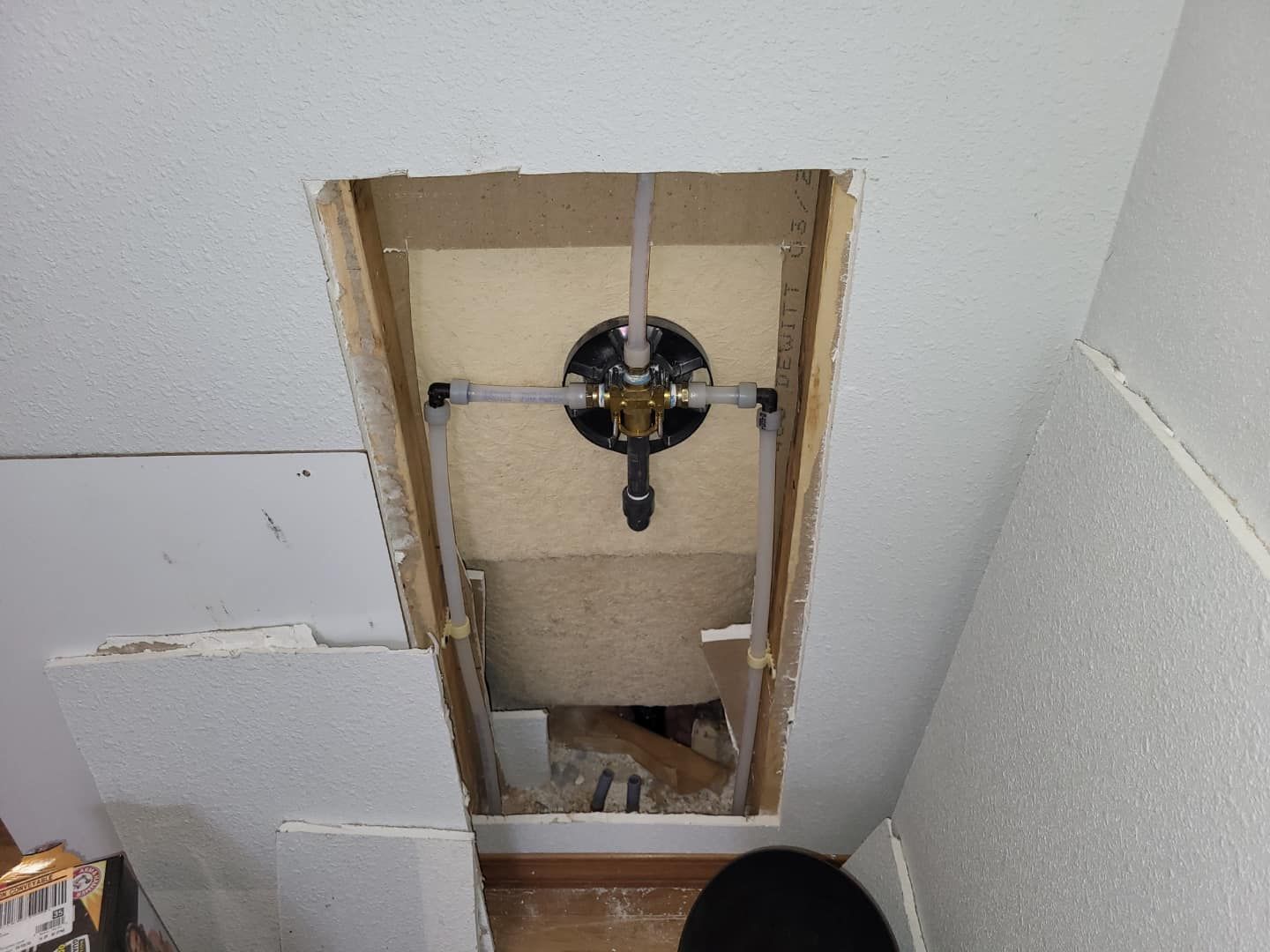 A bathroom with a hole in the wall and a toilet.