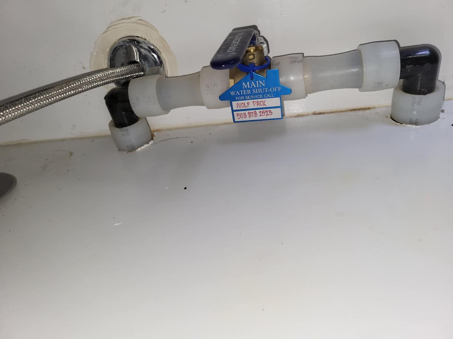 A close up of a water valve on a white surface.