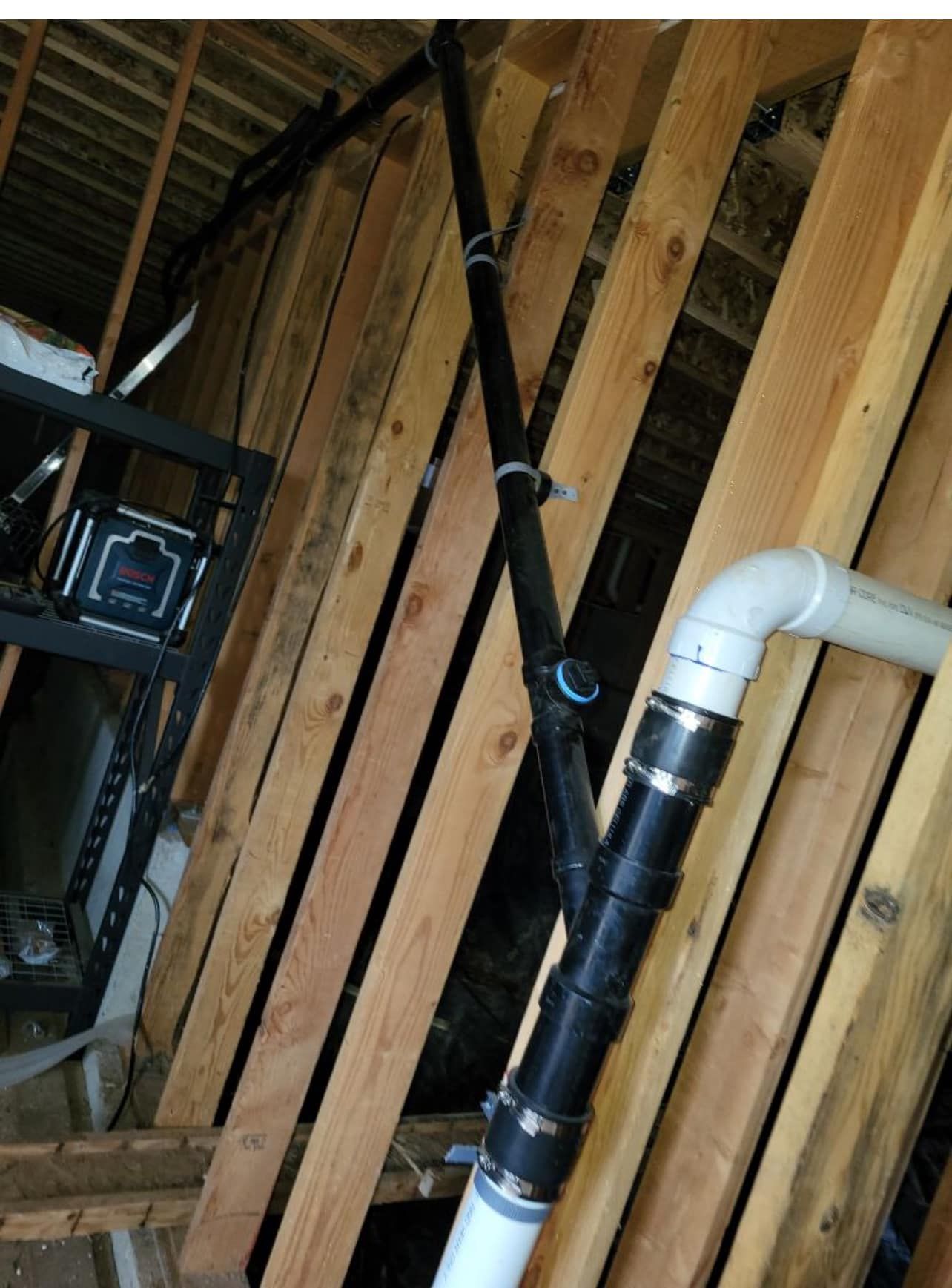 A bunch of pipes are connected to a wooden wall