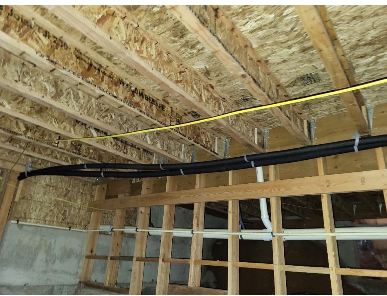 A wooden ceiling with pipes hanging from it