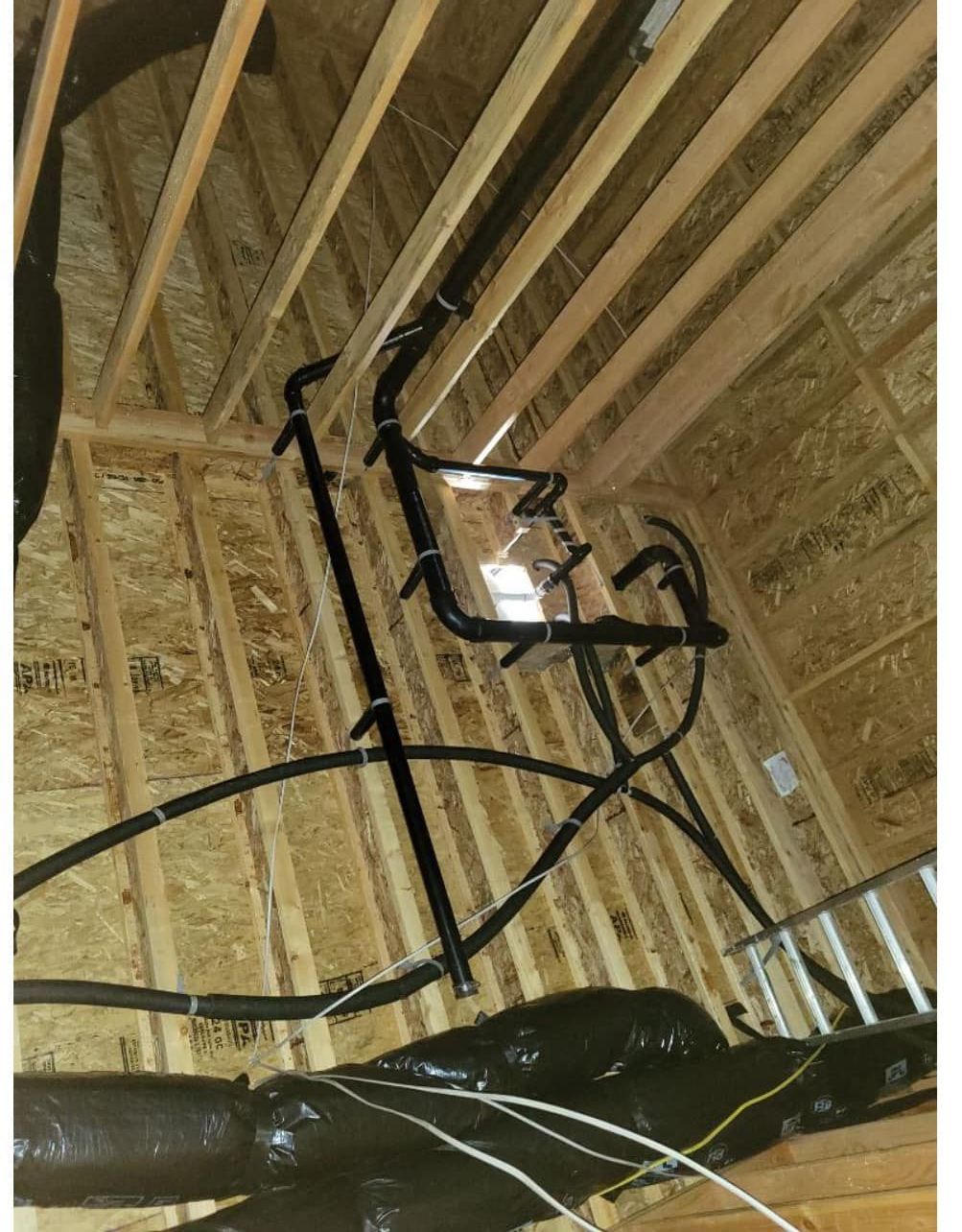 A ladder is hanging from the ceiling of a building under construction.
