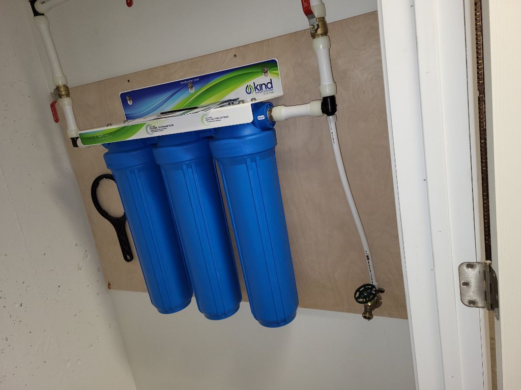 A water filter is hanging on a wall next to a door.