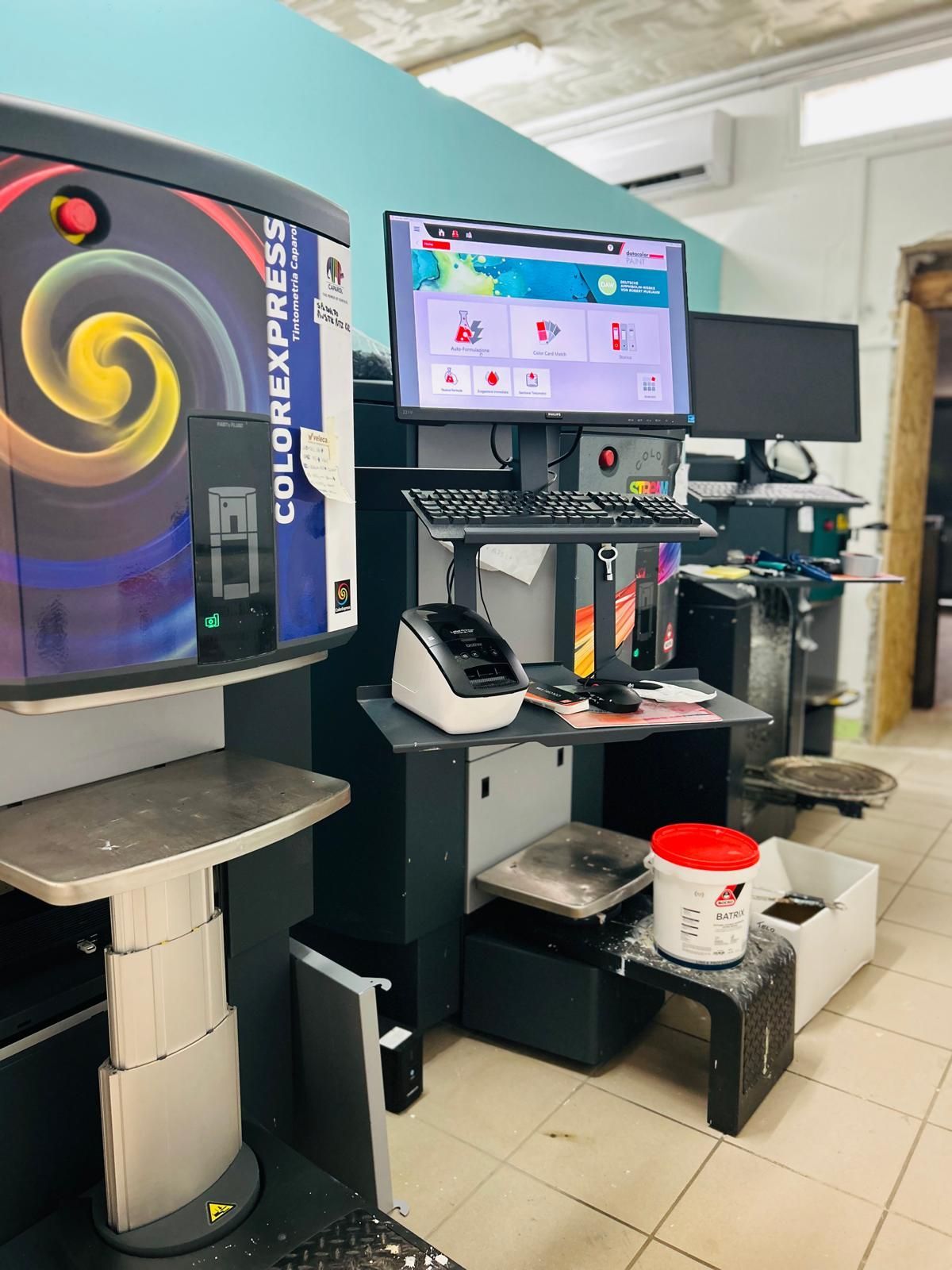 Macchine per la miscelazione dei colori e una postazione computer all'interno di un negozio al dettaglio.