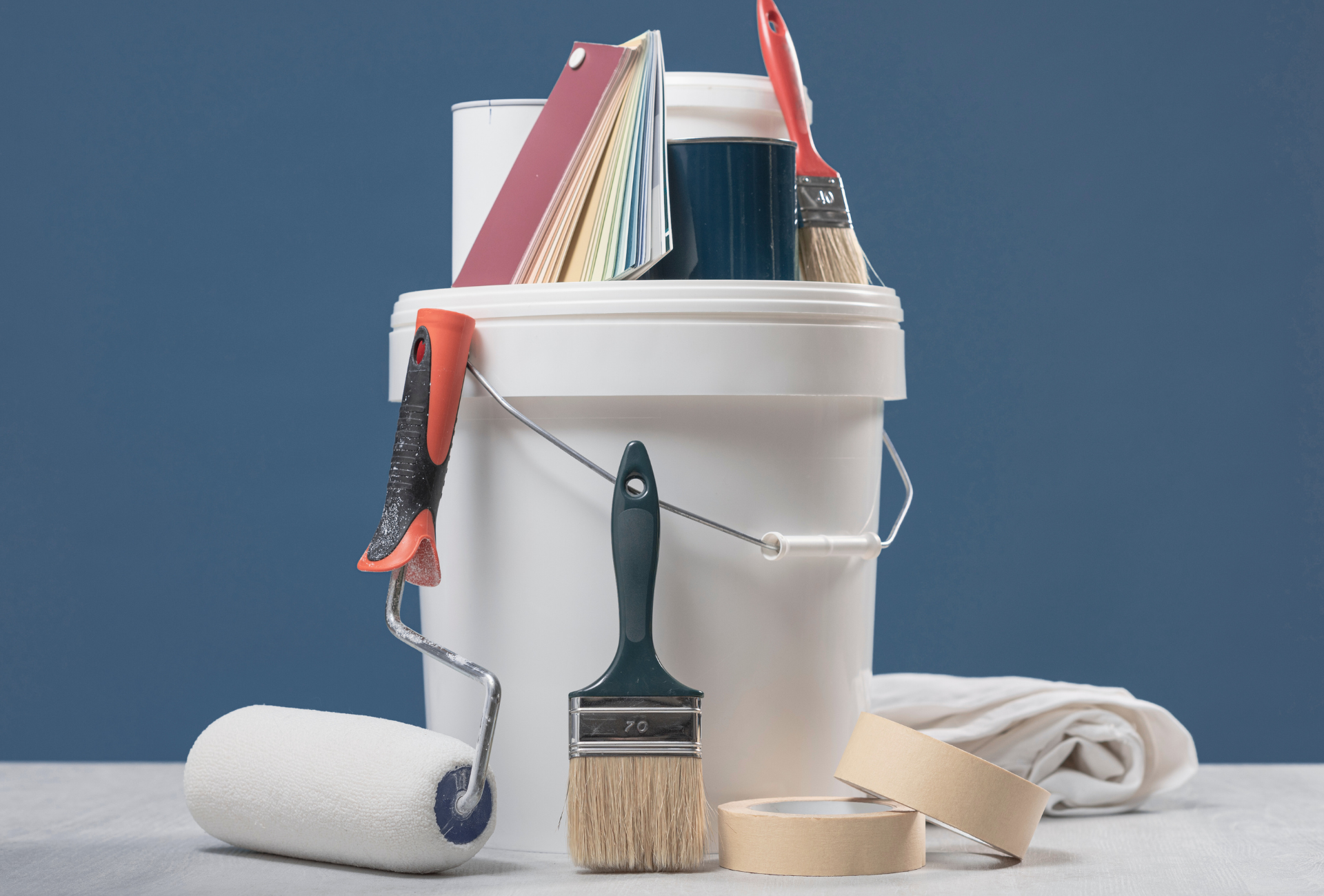 A person is painting a red wall with a paint roller.