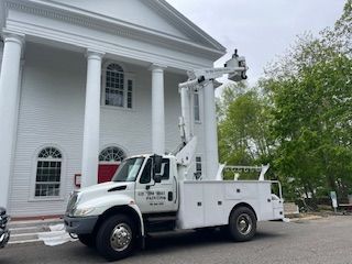 A white truck is parked in front of a white building.