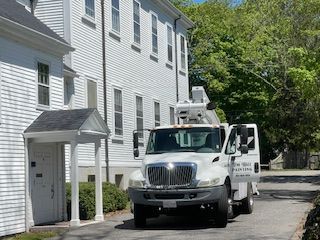 A white truck is parked in front of a white building.