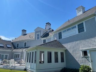 A large house with a large porch and a large roof.