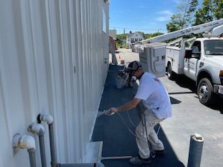 A man is painting the side of a building.
