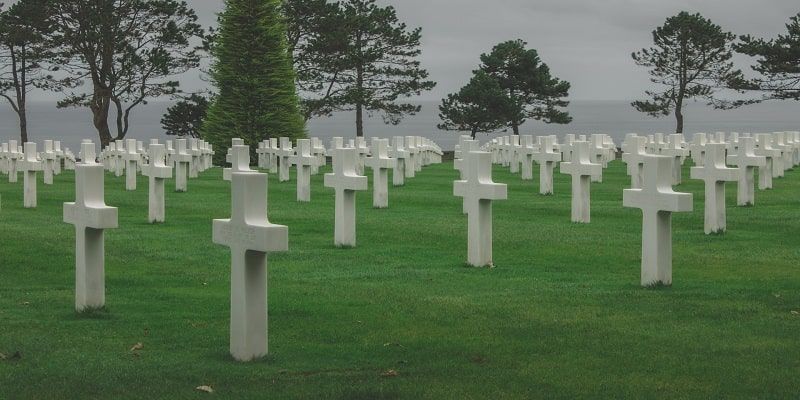 A cemetery with many white crosses in the grass