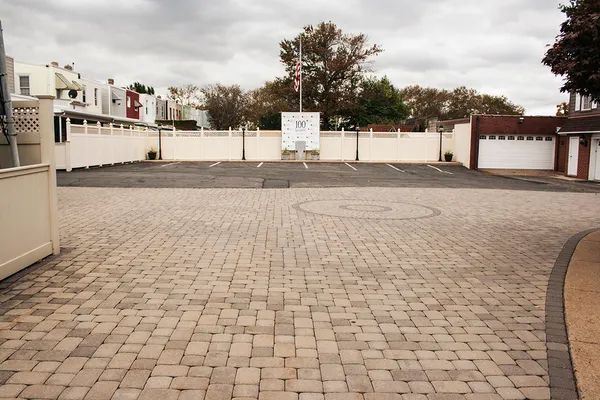 An empty parking lot with a white fence in the background