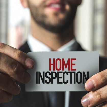 Home inspector holding a card that says home inspection