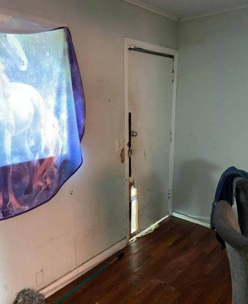 A room with a door and a blanket hanging on the wall.