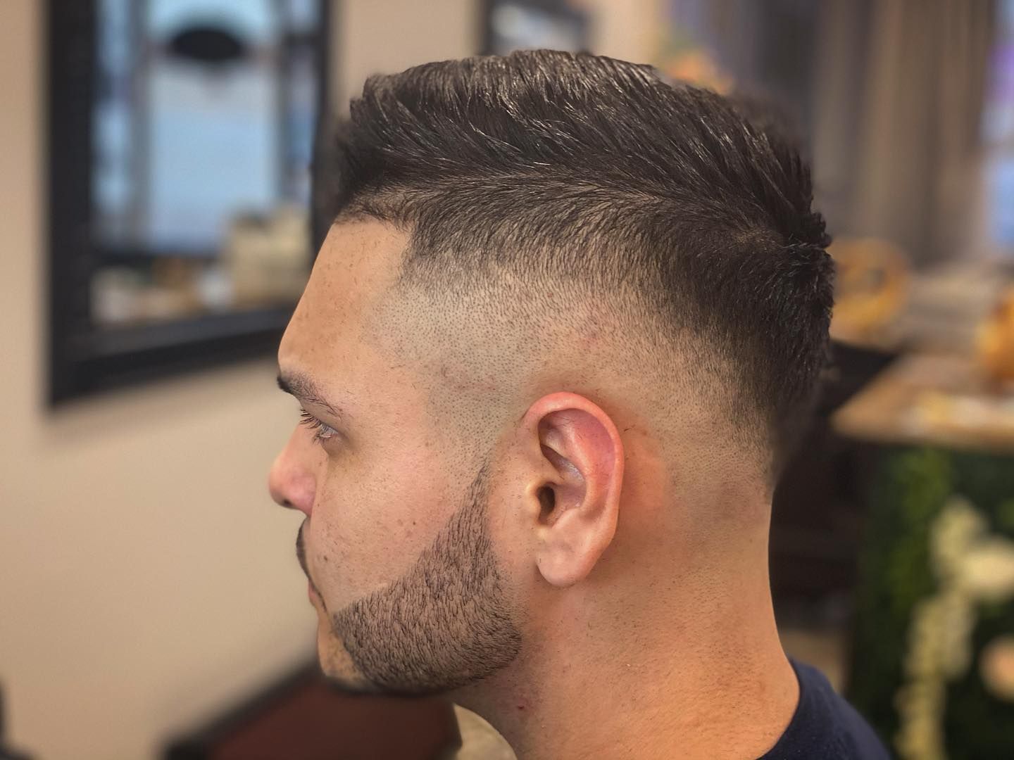 Man with dark hair and beard, faded sides and back, side profile.