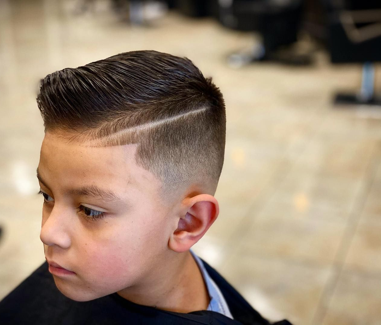 Boy with a faded haircut, side part, and shaved line.
