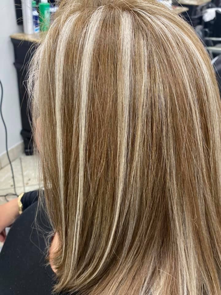 Woman with blonde and brown highlighted hair in a salon.