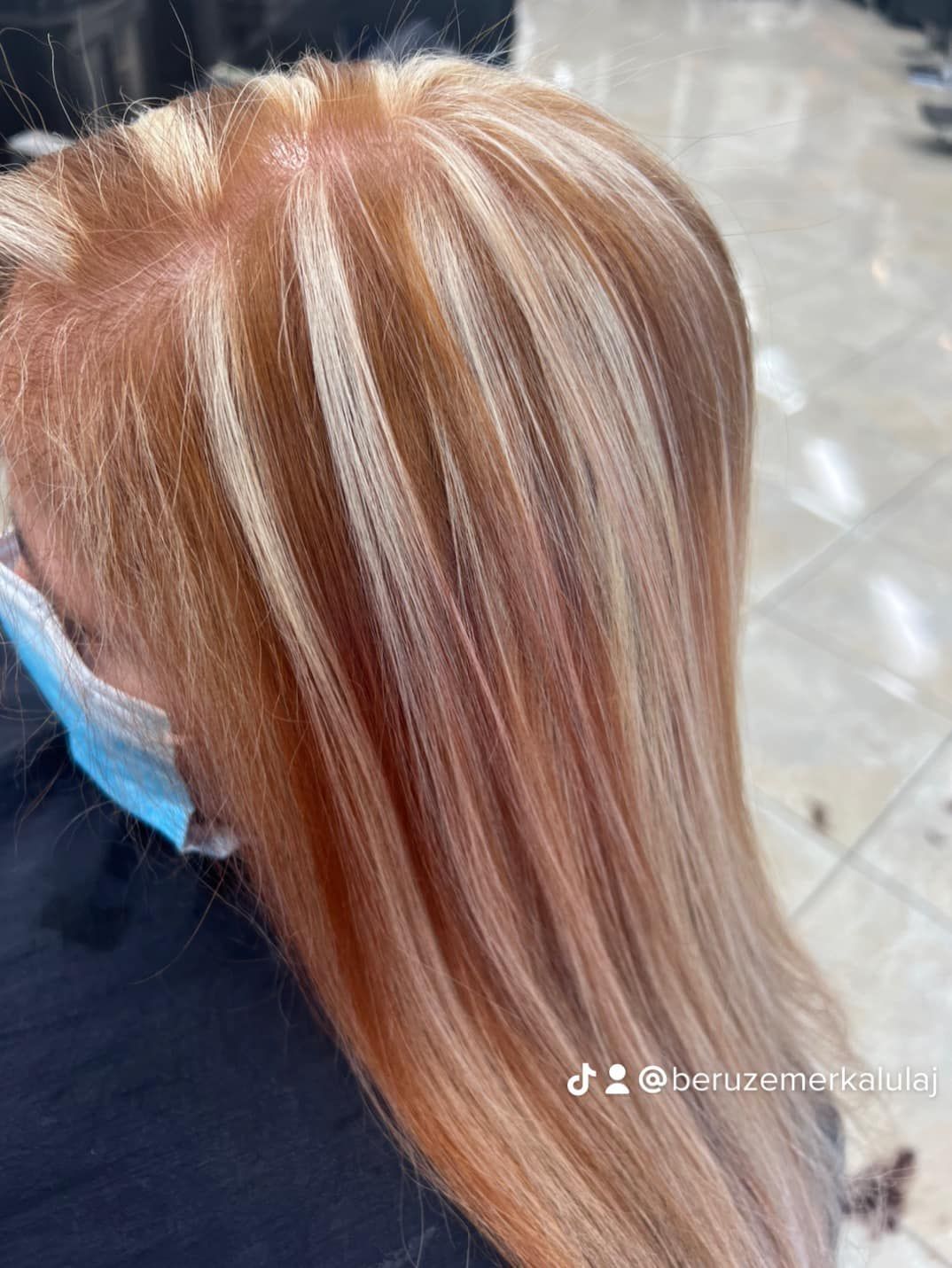 Blonde and peach-colored hair with thick blonde highlights. Close-up view.
