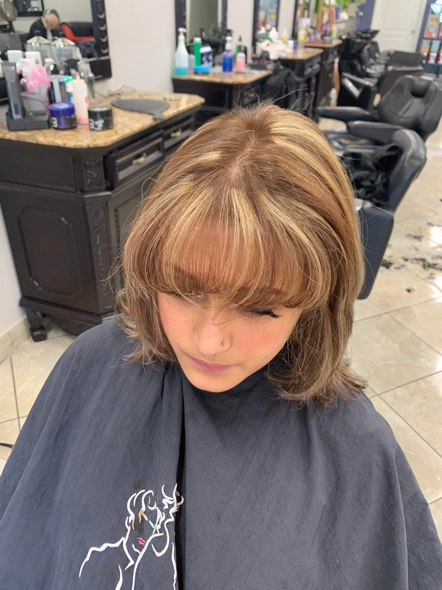 Person with layered haircut, bangs, highlights, in a salon.