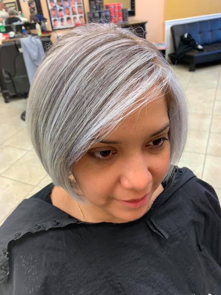 Woman with angled, gray and brown bob in a salon.