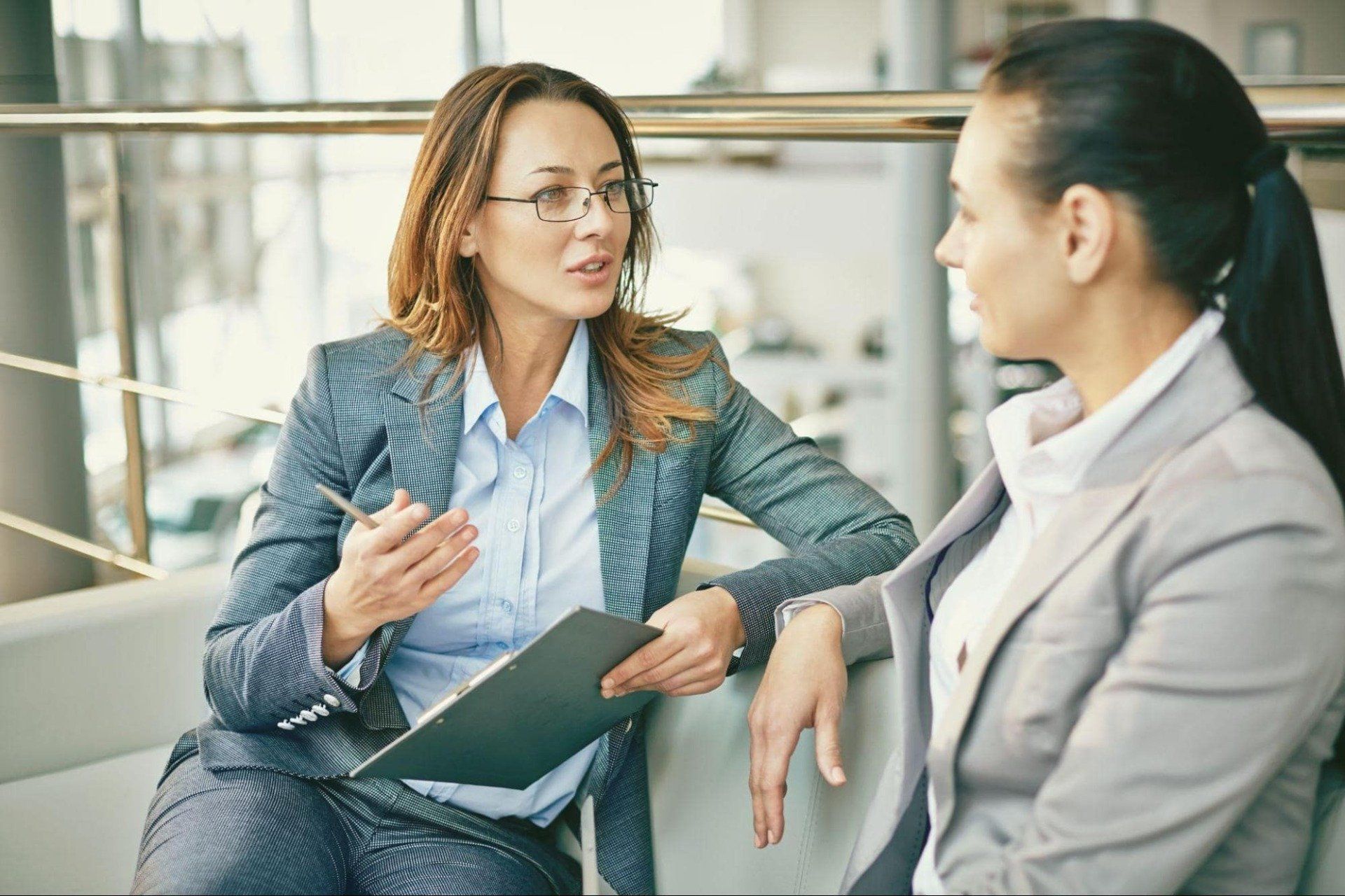 two women talking in business attire