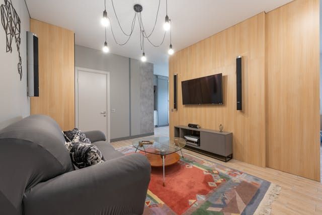 a living room with grey and wooden walls and a grey couch