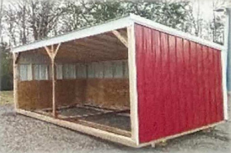 Red wooden animal shelter with open front and pitched roof outdoors
