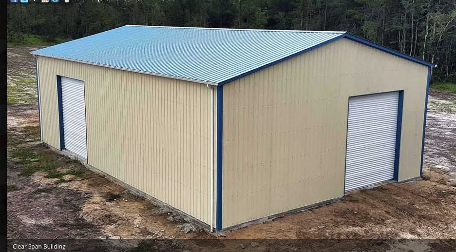 Tan metal storage shed with blue roof and two white roll-up doors on dirt ground.
